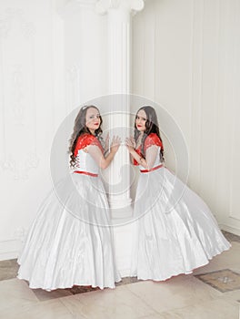 Two Beautiful woman in white and red medieval dresses with crinoline