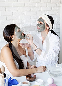 Two beautiful women applying facial mask doing spa procedures