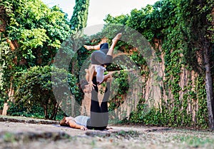 Two beautiful women doing acroyoga in the garden or park