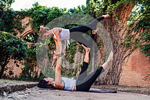 Two beautiful women doing acroyoga in the garden or park