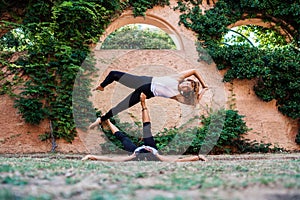 Two beautiful women doing acroyoga in the garden or park