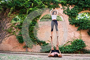 Two beautiful women doing acroyoga in the garden or park