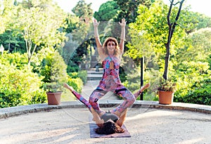 Two beautiful women doing acroyoga in the garden or park