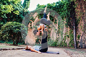 Two beautiful women doing acroyoga in the garden or park