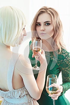 Two beautiful women drink champagne