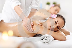 Two beautiful women getting massage in spa