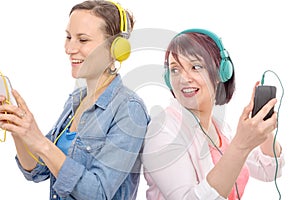 Two beautiful women listening to music with headphones