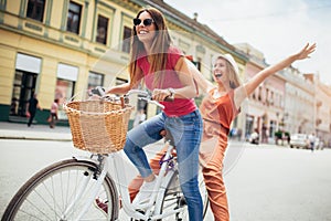 Two beautiful women shopping on bike in the city