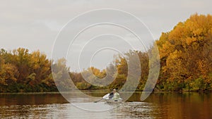 Two beautiful women sits in a boat on a lake in a fairy autumn forest