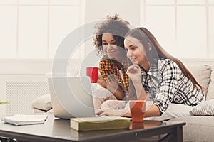 Two beautiful women using laptop at home