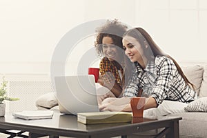 Two beautiful women using laptop at home