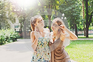 Two beautiful young boho chic stylish girls walking in park.