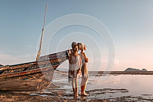 Two beautiful young fashion models on the beach at sea boat