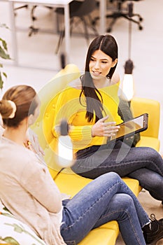 Two beautiful young female business colleagues having a chat in a modern office. Successfull startup team having a brainstorming