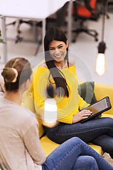 Two beautiful young female business colleagues having a chat in a modern office. Successfull startup team having a brainstorming