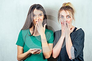 Two beautiful and young girlfriends women gossip. the concept of eavesdropping and gossip