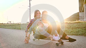 Two beautiful and young women having fun with skateboard