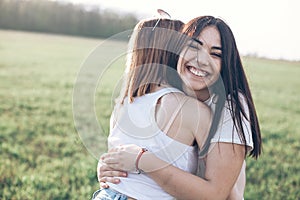Two beautiful young women hugging outdoors