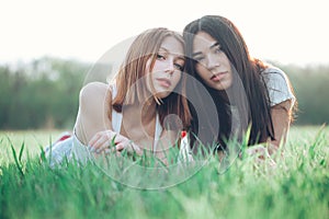 Two young women lie on the iawn