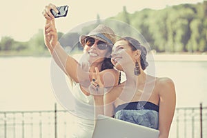 Two beautiful young women making selfie laughing