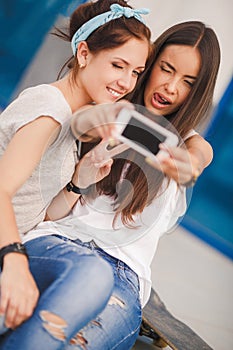 Two beautiful young women making selfie photo