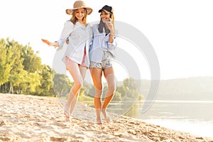 Due bellissimo giovane donne itinerante sul Spiaggia. una donna amici sul Spiaggia un sorridente sul estate 
