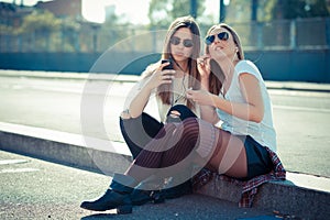 Two beautiful young women using smart phone
