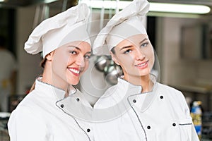 A two beautifull young female chef posing for camera