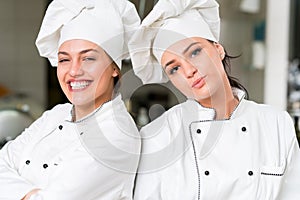 A two beautifull young female chef posing for camera