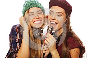 two beauty hipster girls with a microphone singing and having f