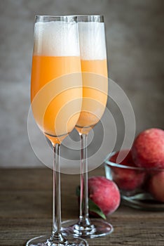 Two bellini cocktails with fresh peaches