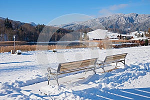two benches at snowy winter landscape, spa garden Schliersee