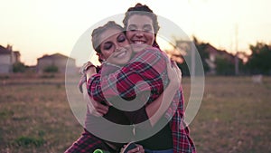 Two best friends hugging each other and looking in the camera smiling. Happy young woman cuddle and hug showing love and