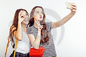 Two best friends teenage girls together having fun, posing emotional on white background, besties happy smiling