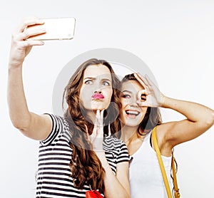 Two best friends teenage girls together having fun, posing emotional on white background, besties happy smiling