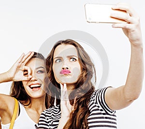 Two best friends teenage girls together having fun, posing emotional on white background, besties happy smiling, making