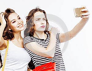 Two best friends teenage girls together having fun, posing emotional on white background, besties happy smiling, making