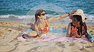 Two best girlfriends relaxing on sandy beach