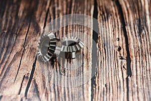 Two bevel gears after manufacturing lie on a wooden background