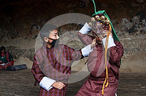 Two boys play with terrifying mask of mask dance , Bumthang, central Bhutan.