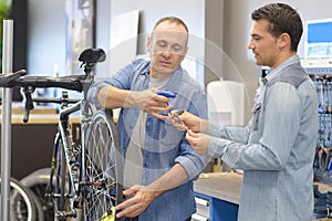 two bicycle repairer colleagues working in bike garage