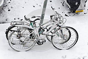 Two bicycles covered in snow