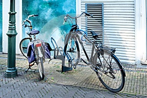 Two bicycles parked in front of a house wall