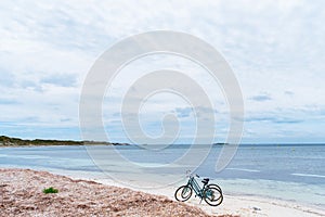 Two bicycles parked on sandy beach on Rottnest Island, Western Australia.