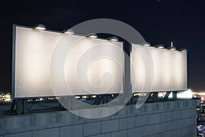 Two big empty billboard on the background of the city at night,