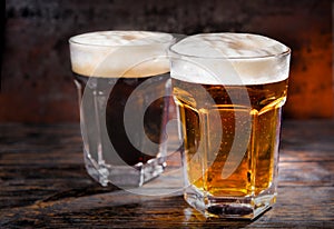 Two big glasses with freshly poured dark and light beer and head photo