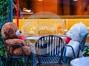 Two big stuffed teddy bears out for a romantic dinner