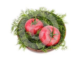 Two big tomatoes with fresh dill in a wooden basket, isolated on a white background. Vegetarian food concept, top view.