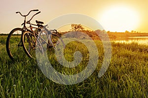 Two bike near the lake sunset background. Two vintage bicycles at sunset. The concept of romance and love