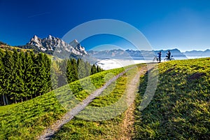 Two bikers looking at the Mythen peaks in Swiss Alps photo
